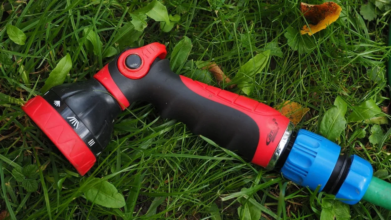 Close-up of white hard water stains and mineral spots on a clear shower glass door.