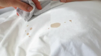 Close-up of a white pillowcase with foundation and mascara stains, showing effective pre-laundry stain removal techniques.
