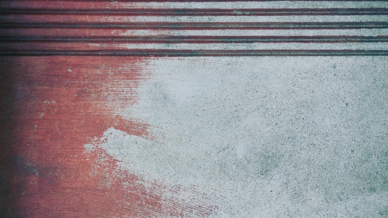 Close-up of rust stains on a concrete garage floor, showing treatment methods.
