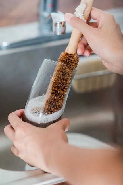 Person Cleaning A White Sneaker With Brush And Soapy Water